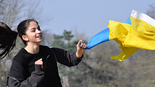 Mädchen laufend, eine Ukraine-Flagge haltend
