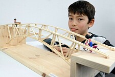 Ein junge präsentiert seine selbst konstruierte Brücke