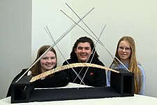 Schüler:inn stehen vor ihrer selbstkonstruierten Brücke