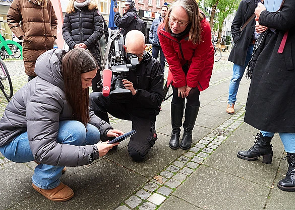 Senatorin Aulepp schaut sich an, wie die Stolpersteine-App von einer Schülerin genutzt wird.
