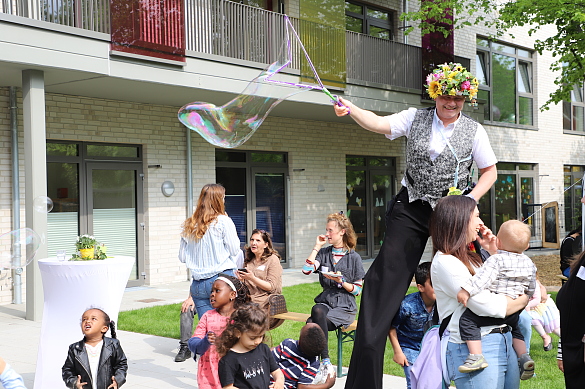Mann, der auf Stelzen Seifenblasen pustet
