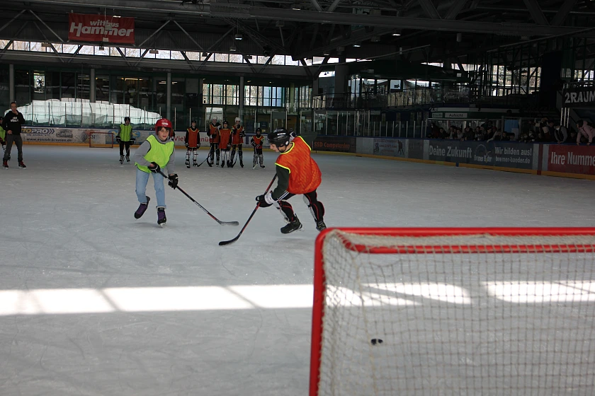 Hier sieht man einen jungen, der Eishockey spielt