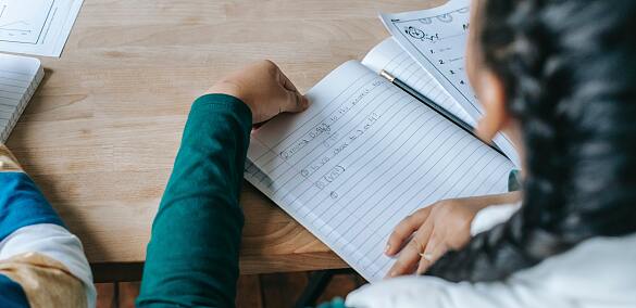 Mädchen, das etwas in ein Heft schreibt