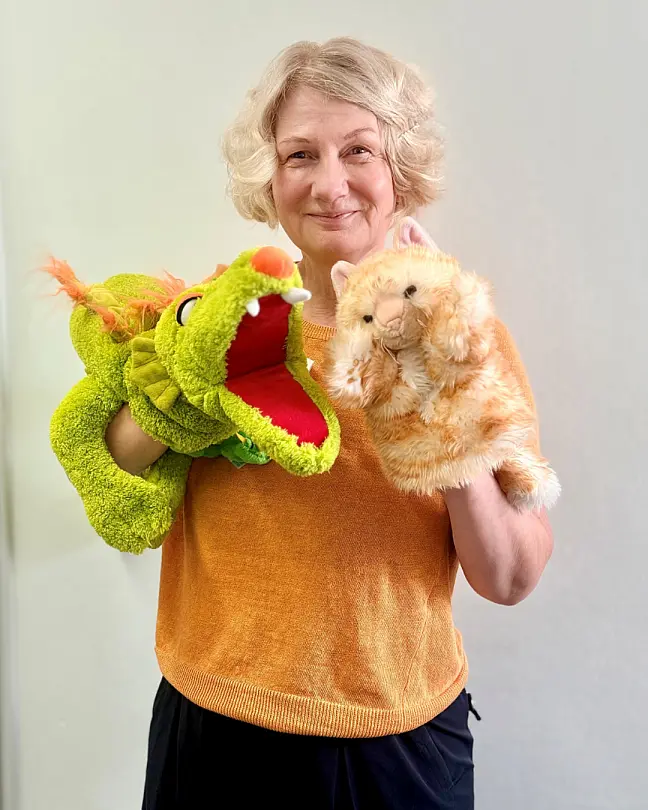 Eine Frau, die zwei Handpuppen in der Hand hält
