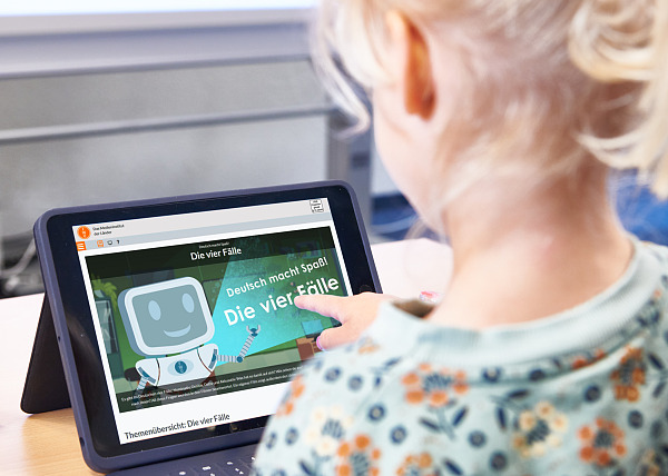 Mädchen arbeitet am iPad mit einem Medium aus dem MedienOnline-Bestand