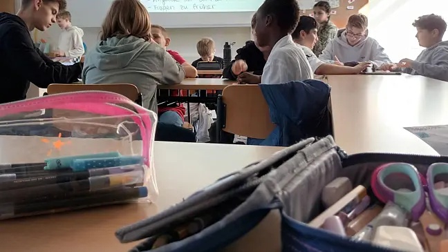 Schüler:innen in einem Klassenraum, die schreiben. 