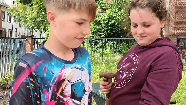 Schüler:innen, die eine Wildblumenwiese pflanzen