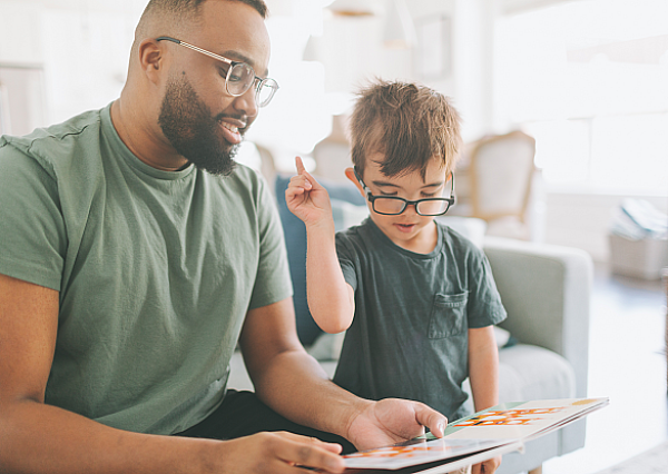 Mann, der einem Kind bei seinen Aufgaben hilft