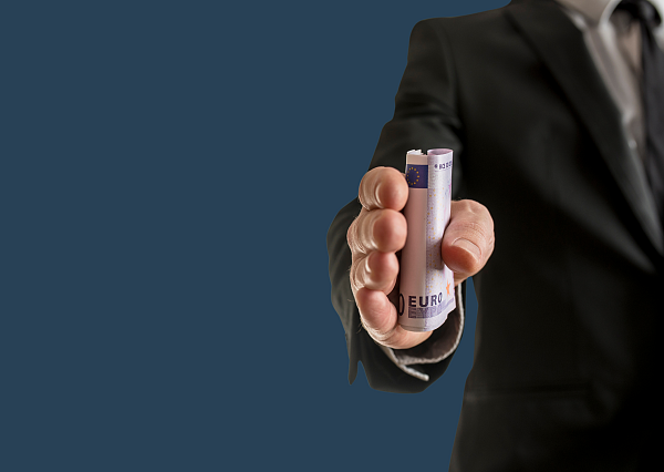 Mann im Anzug, der einen Geldschein in die Kamera hält