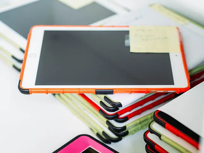 Mehrere iPads in bunten Hüllen aufgestapelt.