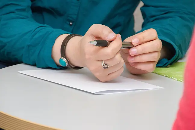 Hände die einen Stift halten und ein Block
