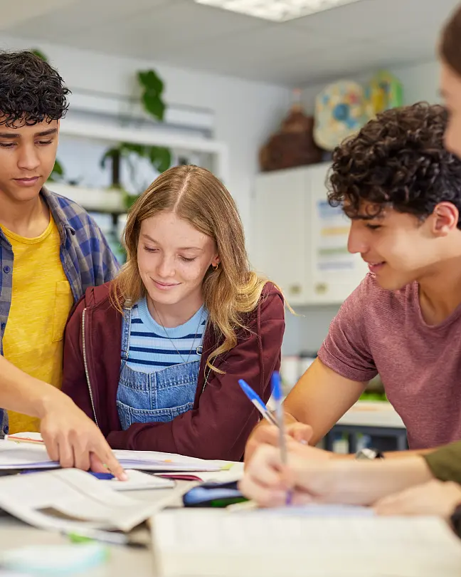 Schüler:innen, die gemeinsam an einem Plakat arbeiten
