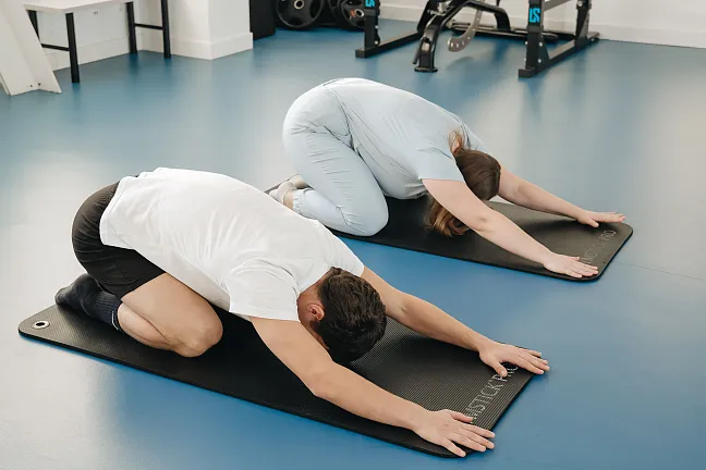 Zwei Menschen, die auf einer Yogamatte liegen