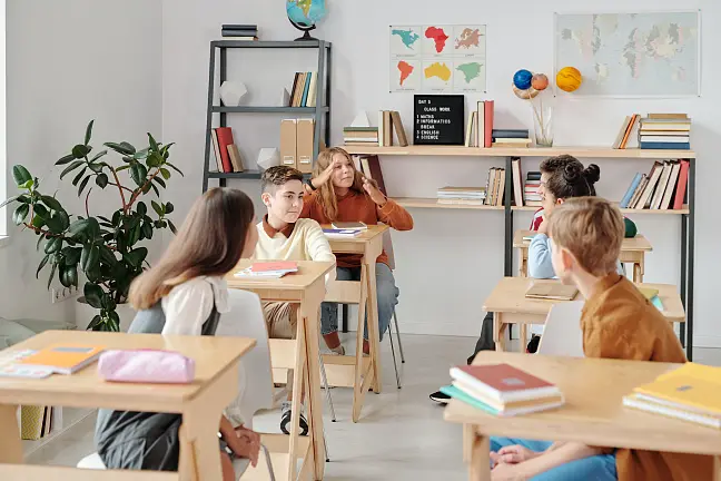 Klassenraum mit Kindern an Tischen. 