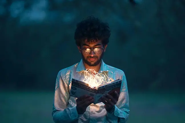 Mann, der in ein Buch schaut, welches leuchtet
