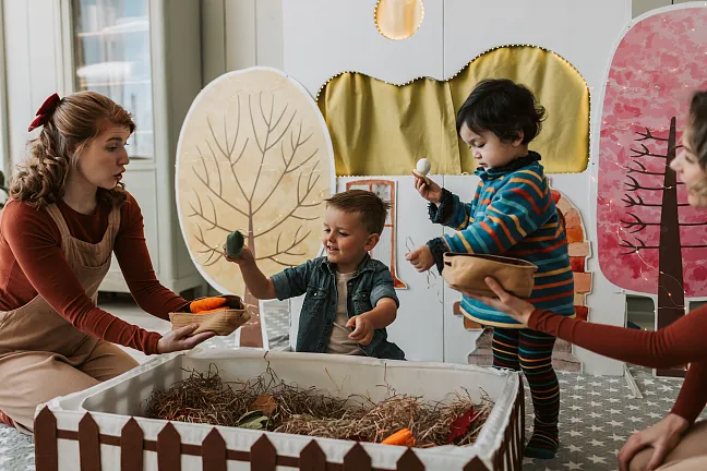 Kinder, die mit ihrer Erzieherin etwas malen