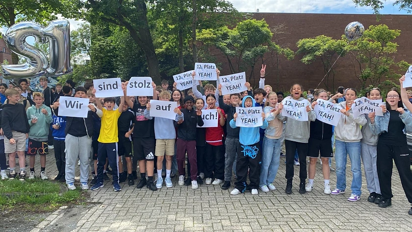 Schüler:innen stehen mit Schildern 