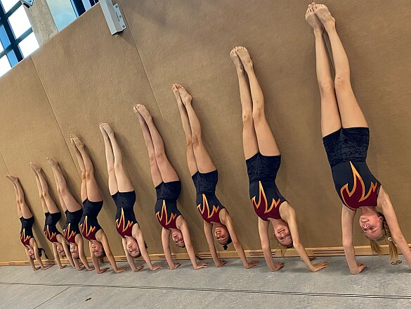 Turnerinnen, die an der Wand einen Handstand machen