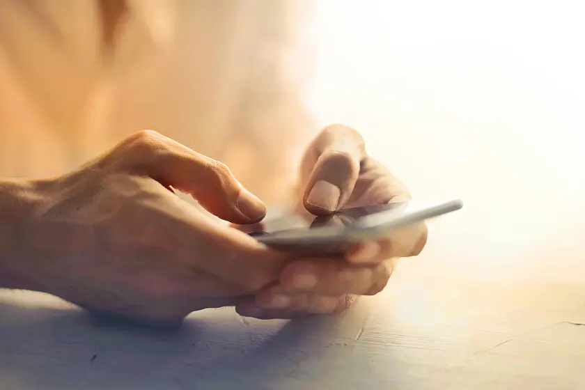 Zwei Hände, die ein Smartphone halten