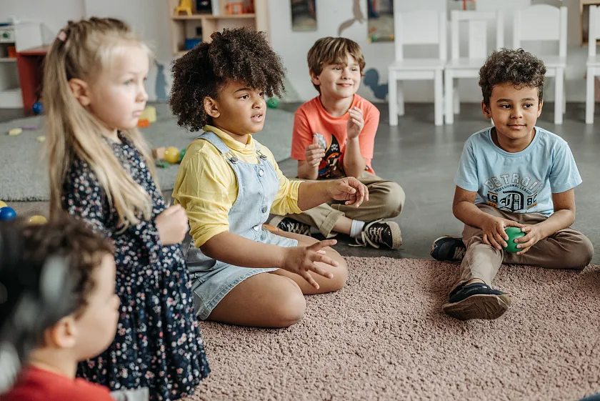 Kinder, die auf dem Boden sitzen und ein Spiel spielen