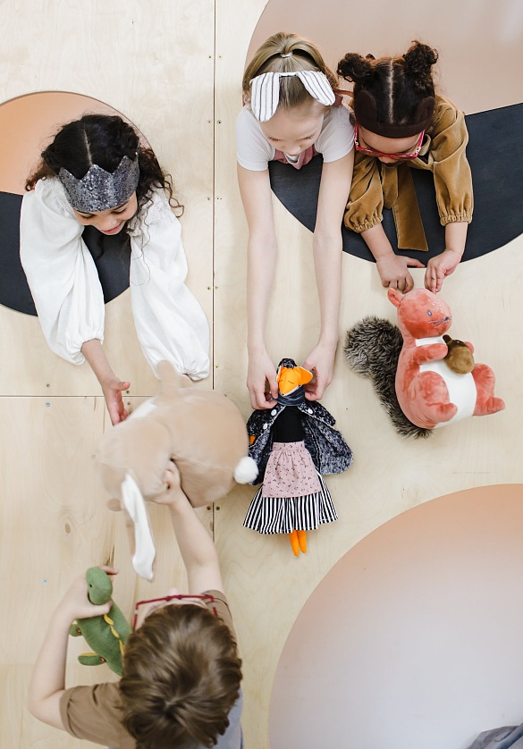 Kinder, die sich Kuscheltiere hin und herreichen